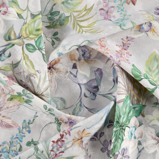 A close-up view of a fabric with a floral pattern featuring various colors such as pink, green, and white on a, likely cotton, textile.