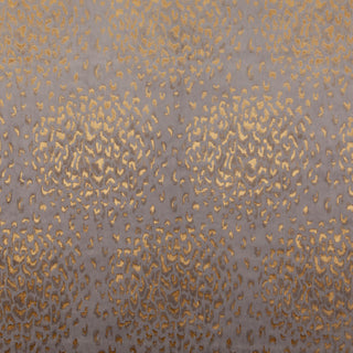 Close-up of a velvet fabric with a pattern of gold splodges on a dark background, giving a luxurious appearance.