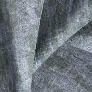 Close-up view of a fabric with a blue and gray abstract pattern, likely used for drapery.