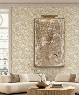 Vivid Collection wallpaper featuring a scalloped fan marbled motif in soft beige, gold, and pastel accents, styled behind cream sofas, a round wooden coffee table, and a large abstract framed artwork illuminated by a brass picture light.