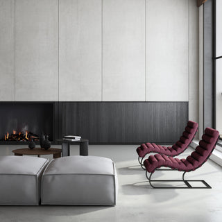 Woolish collection upholstery featuring deep burgundy channel-tufted chaise loungers and light grey ottomans, styled in a sleek contemporary living space with a modern fireplace, black accent tables, and large panel walls.
