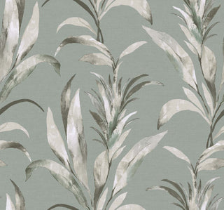 Crown Bali Tropical Padma wallpaper featuring a dramatic botanical design. Tall, stylized tropical leafy foliage in whate and light grey tones stands gracefully against a textured light blue-grey background, creating a moody, sophisticated accent wall.