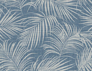 Crown Bali Tropical Jiva wallpaper featuring a tropical palm frond motif. Overlapping off-white palm leaves spread gracefully across a denim blue woven linen-look background, offering a relaxed, coastal-inspired aesthetic for walls.