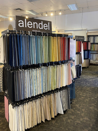 Display of colorful swatches with 'alendel' branding in a showroom setting.