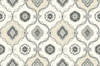 A close-up view of the Avignon wallpaper swatch from the Crown Provence collection. The pattern features a classic ogee trellis layout, formed by delicate, interlocking leafy vine borders in deep charcoal and mid-grey. Alternating compartments enclose intricate, circular floral mandalas and ornate, four-lobed medallion motifs. The elegant, symmetrical design is set against a warm cream background enhanced by a subtle linen-textured faux weave, creating a timeless and sophisticated aesthetic.