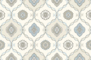 A close-up view of the Avignon wallpaper swatch from the Crown Provence collection. The pattern features a classic ogee trellis layout, formed by delicate, interlocking leafy vine borders in light blue and beige. Alternating compartments enclose intricate, circular floral mandalas and ornate, four-lobed medallion motifs. The elegant, symmetrical design is set against a warm cream background enhanced by a subtle linen-textured faux weave, creating a timeless and sophisticated aesthetic.