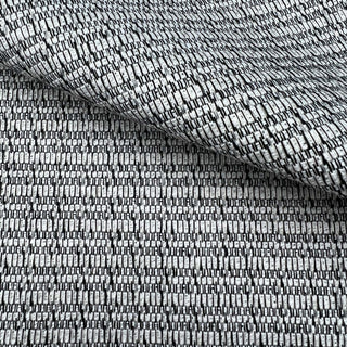 JF Fabrics St. Tropez fabric collection. A close-up view of a textured black grey and cream fabric with a subtle pattern