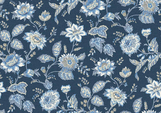 A close-up view of the Castellane wallpaper swatch from the Crown Provence collection. The pattern features a sprawling, traditional floral trail design with detailed botanical blossoms, twisting stems, and leafy sprigs. The flowers and foliage are illustrated in soft shades of French blue, white, and taupe, contrasting beautifully against a rich blue background. A subtle, linen-textured faux weave runs across the surface, giving the elegant, country-cottage print an inviting, fabric-like de