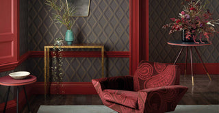 Decorative interior with  Cole & Son's Contemporary Restyled collection  upholstered red armchair, side table, and  Cole & Son's Contemporary Restyled collection wallpaper patterns.