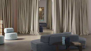 Modern living room with large beige curtains and a gray sofa.