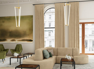 JF Fabrics - Fabric Collection. Modern living room featuring a beige sectional sofa, and green armchairs from the Tonic collection, and large windows with drapery fabric from JF Fabric Drapery collection.