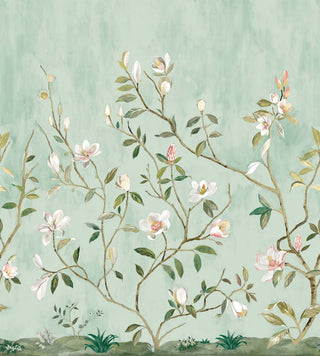 A wallpaper swatch from Crown’s Chinoiserie collection featuring the Kaiyu Dogwood Mural, with flowering branches rising against a soft muted green background. White and pink blossoms, green leaves, and small buds create a serene botanical scene. Subtle painted texture and low foliage at the base add depth, giving the design an elegant, natural, hand‑crafted feel