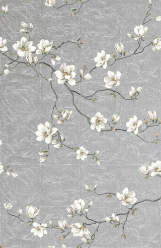 Close-up swatch of Crown's Chinoiserie collection wallpaper in the Moonlace Magnolia pattern. Set against a textured, silver grey background with a subtle, painterly grasscloth finish, the elegant design features delicate trailing branches sweeping across the canvas. The slender branches are adorned with large, realistically rendered white magnolia blossoms in full bloom, along with many small, tightly closed flower buds and sparse, delicate green leaves, creating a serene and luxurious botanical look.